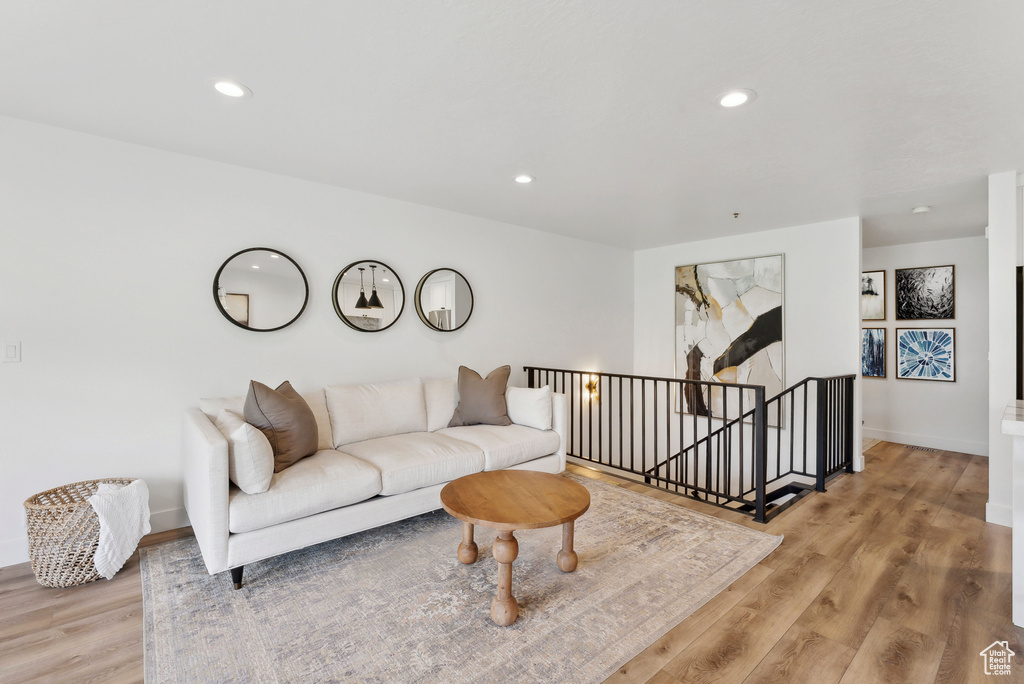 Living area featuring light wood finished floors, baseboards, and recessed lighting