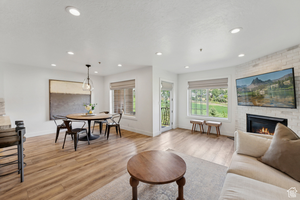 Living room featuring a fireplace, light wood-style floors, recessed lighting, and baseboards