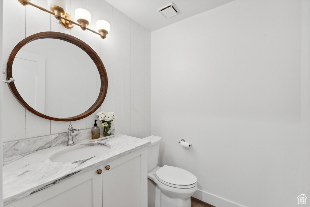 Half bathroom with vanity and toilet