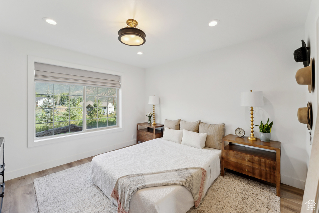 Bedroom with wood finished floors, recessed lighting, and baseboards