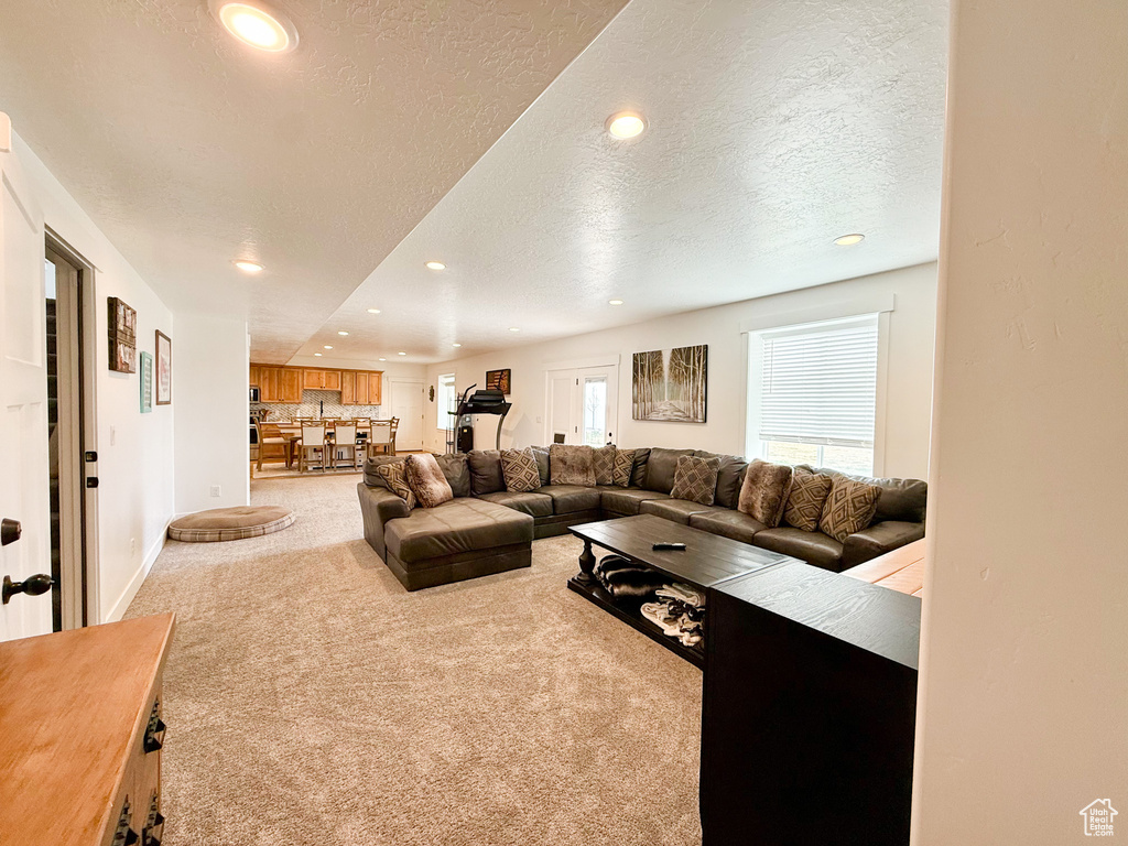 Carpeted living area featuring a textured ceiling and recessed lighting