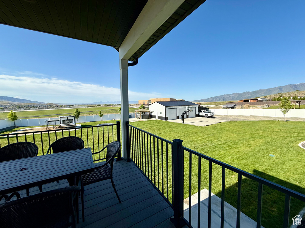 Wooden terrace with a water and mountain view and outdoor dining area