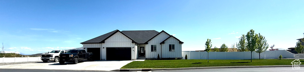 Modern farmhouse featuring an attached garage, concrete driveway, and board and batten siding