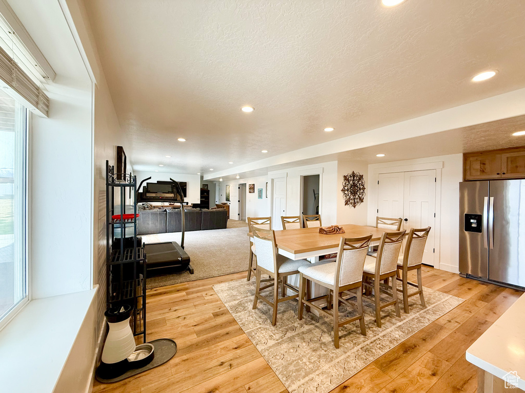 Dining space with light wood finished floors, recessed lighting, and plenty of natural light