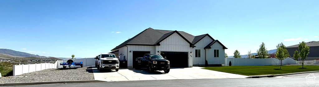 View of front of house featuring concrete driveway, an attached garage, board and batten siding, and a mountain view