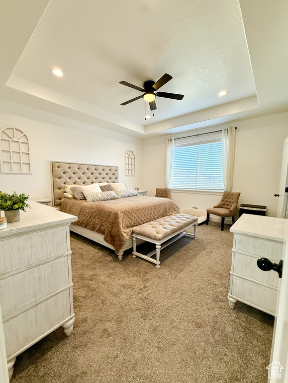 Carpeted bedroom featuring a tray ceiling, recessed lighting, and a ceiling fan