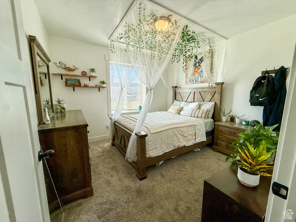 Carpeted bedroom with a textured ceiling and baseboards