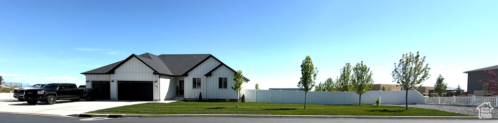 View of front of property with a garage, concrete driveway, and board and batten siding