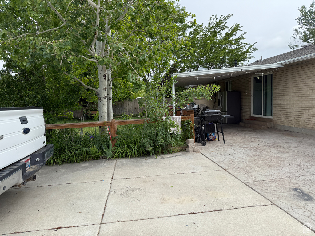 View of patio / terrace featuring entry steps, concrete driveway, and an attached carport