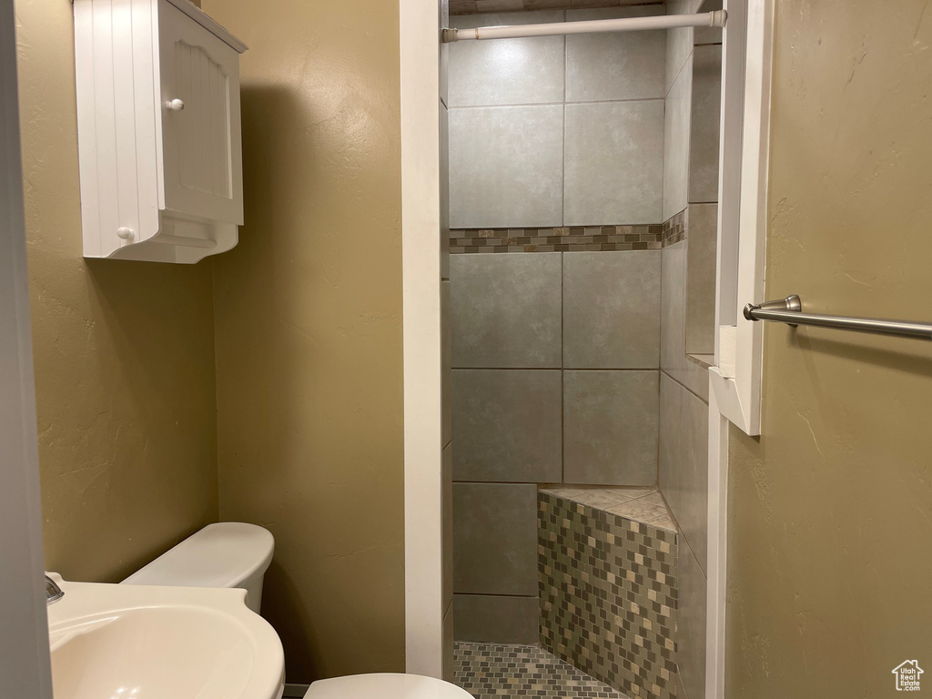 Bathroom with a stall shower, toilet, and a sink