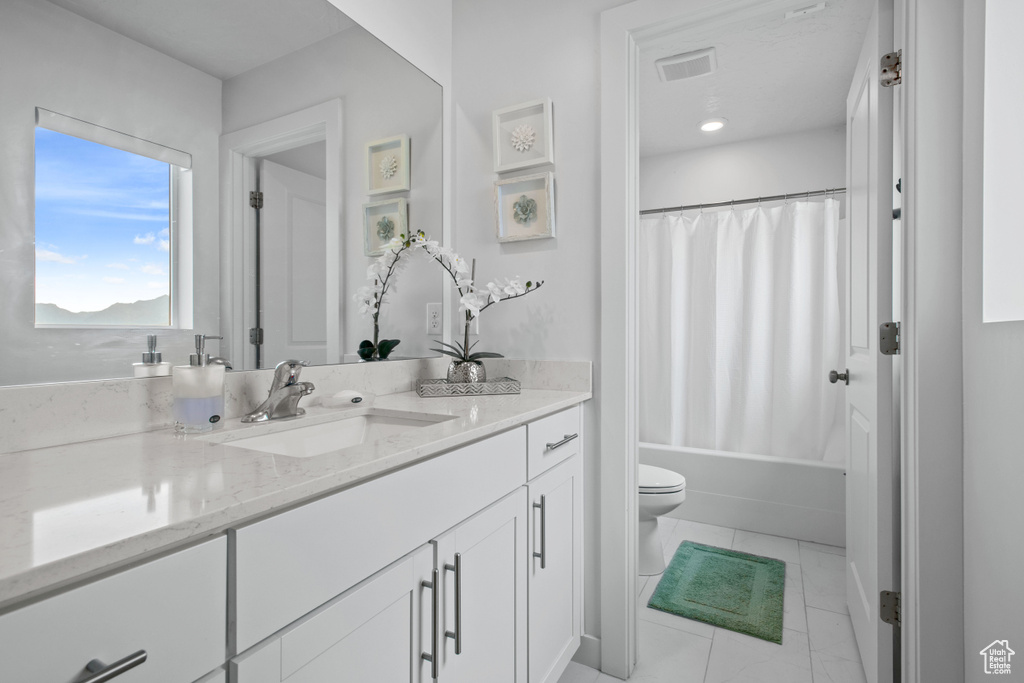 Bathroom with vanity, toilet, and shower / tub combo
