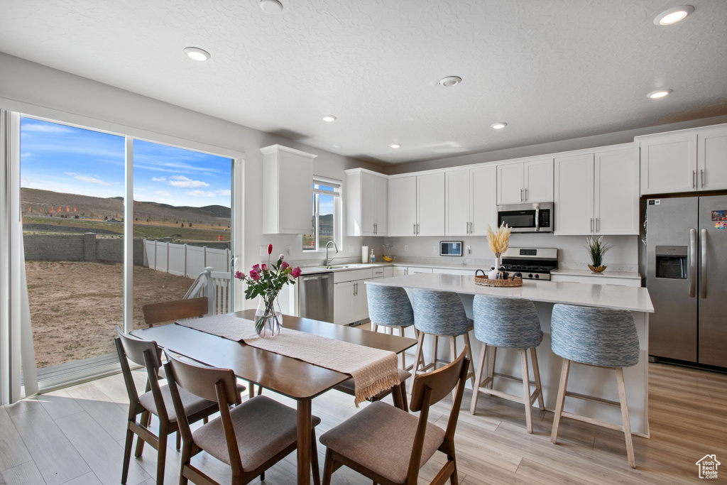 Dining space featuring light wood-style flooring and recessed lighting