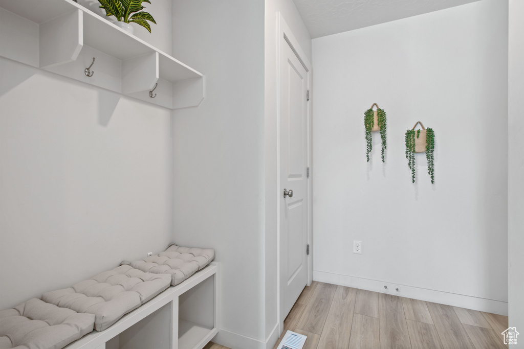 Mudroom with light wood finished floors and baseboards