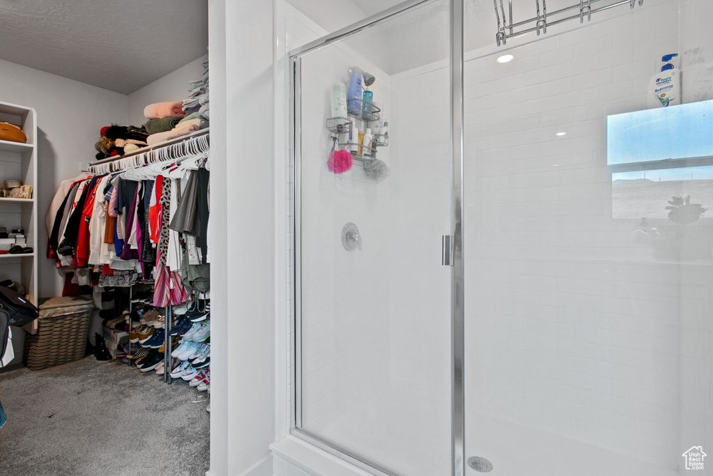 Bathroom featuring a stall shower and a walk in closet