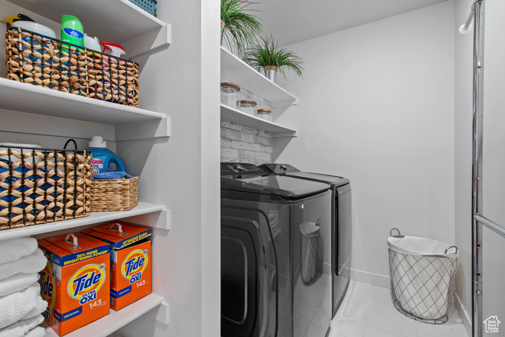 Washroom featuring washer and clothes dryer and baseboards