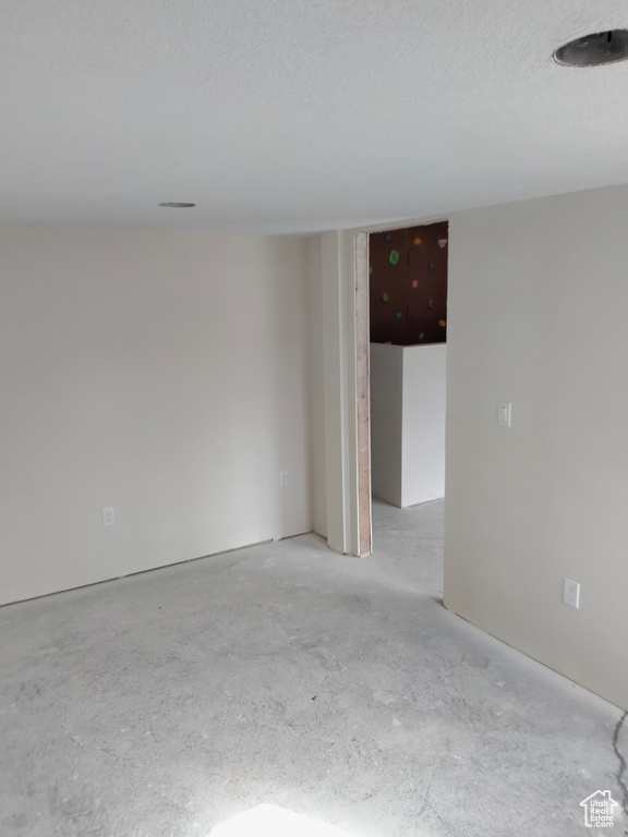 Unfurnished room with unfinished concrete flooring