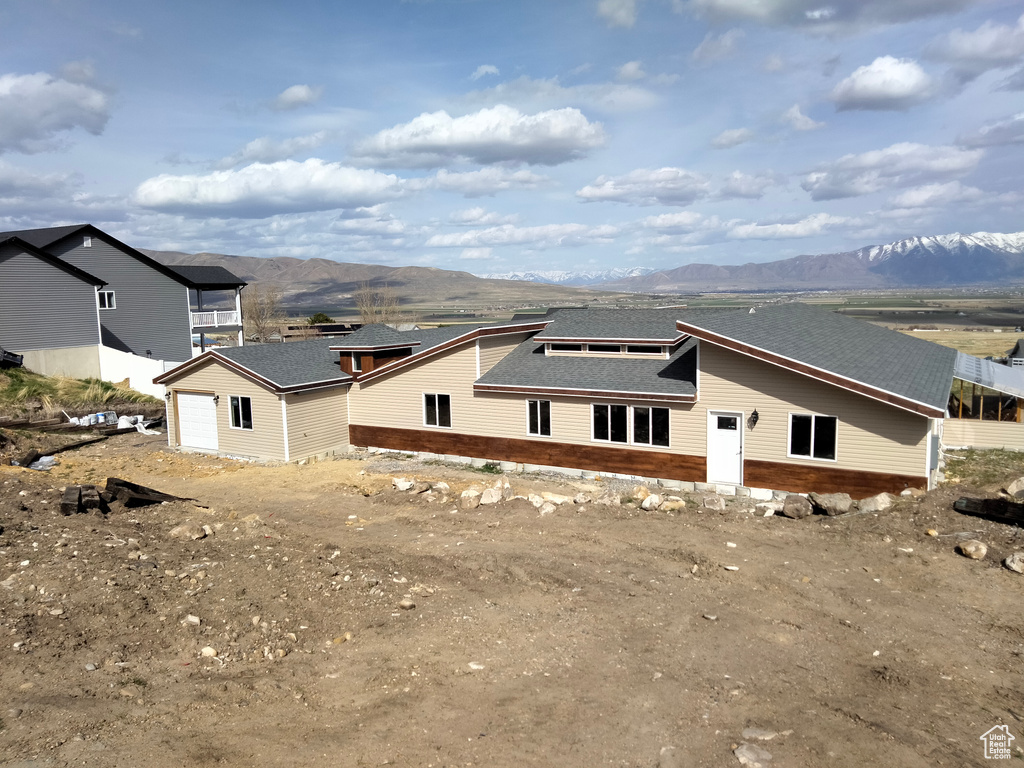 Rear view of house featuring a mountain view and a shingled roof
