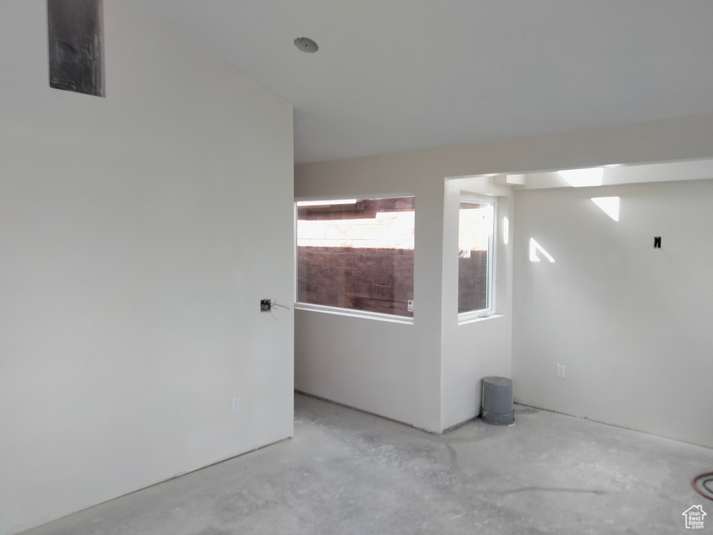 Unfurnished room featuring unfinished concrete flooring
