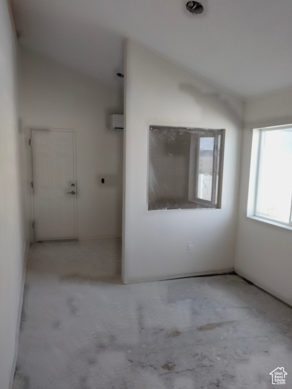 Unfurnished room with concrete floors and a wall unit AC