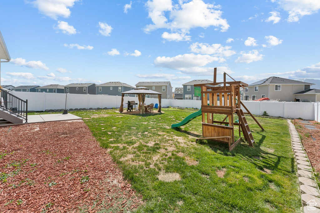 View of yard featuring a gazebo, a residential view, a playground, and a patio