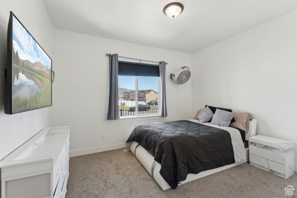 Bedroom with light colored carpet and baseboards