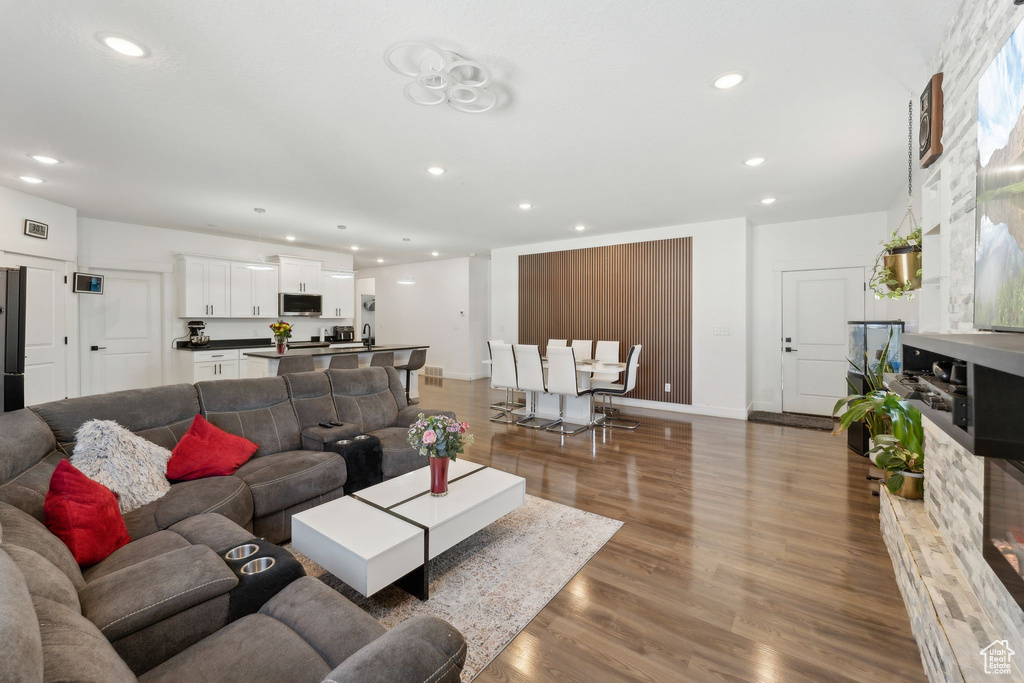Living area with recessed lighting, wood finished floors, and baseboards