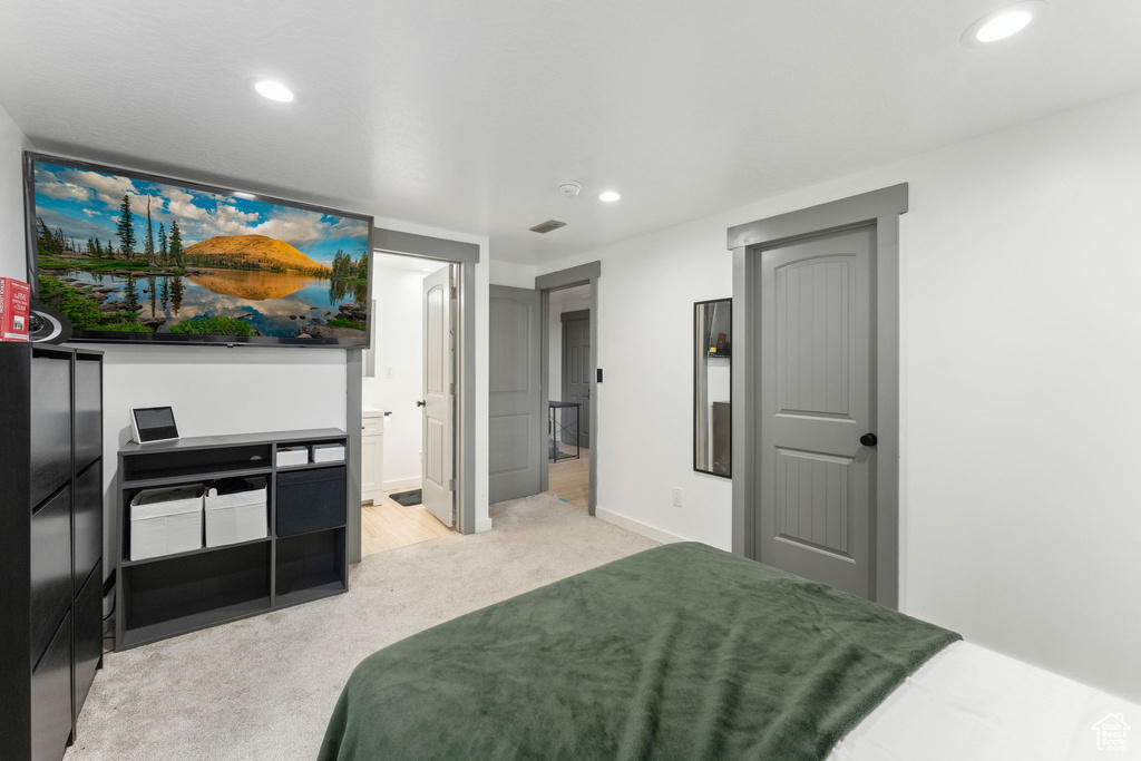 Bedroom featuring light colored carpet, recessed lighting, baseboards, and connected bathroom