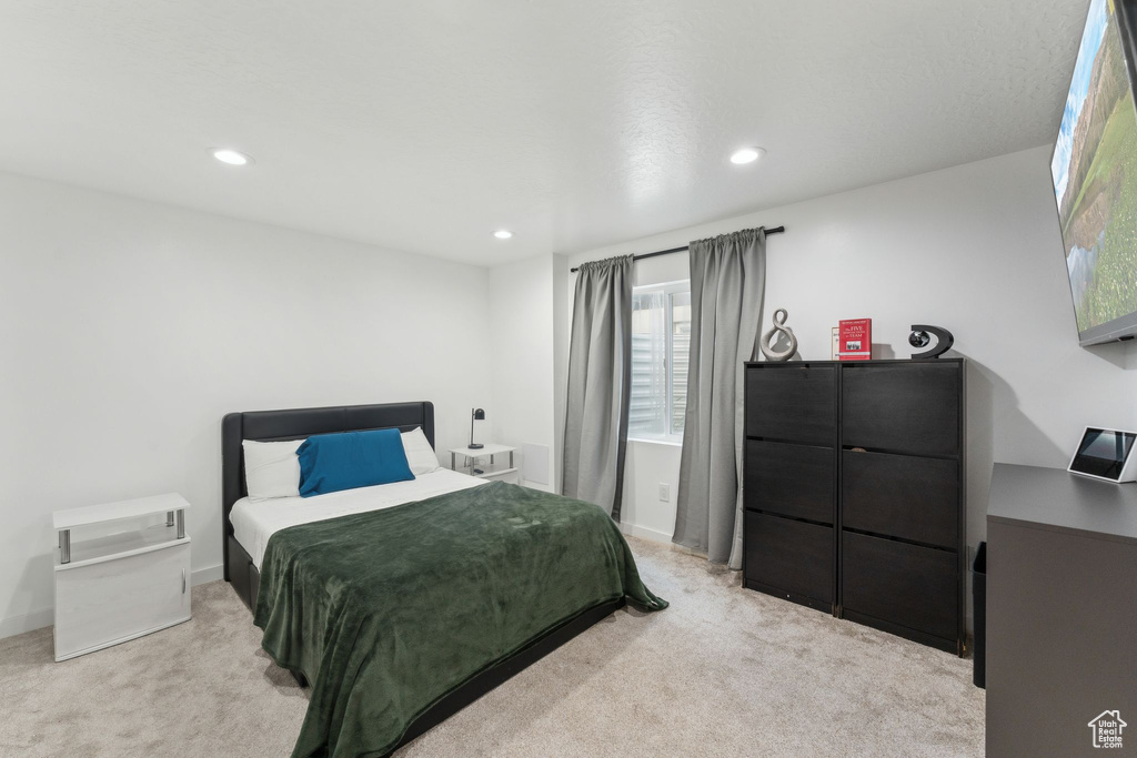 Bedroom with light colored carpet and recessed lighting