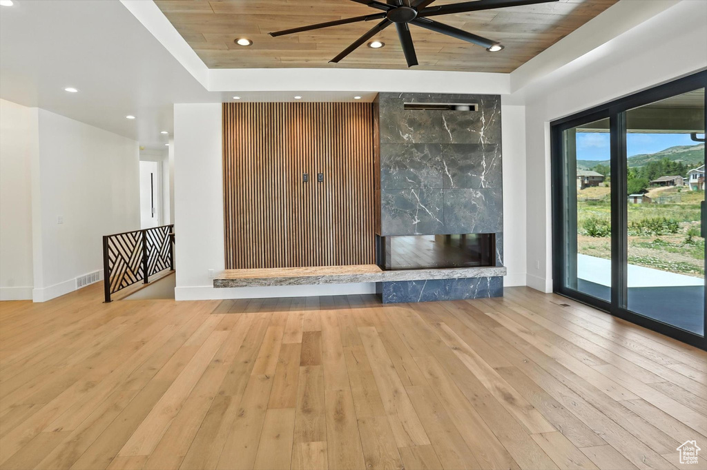 Unfurnished living room with ceiling fan, hardwood / wood-style flooring, recessed lighting, a high end fireplace, and wooden ceiling