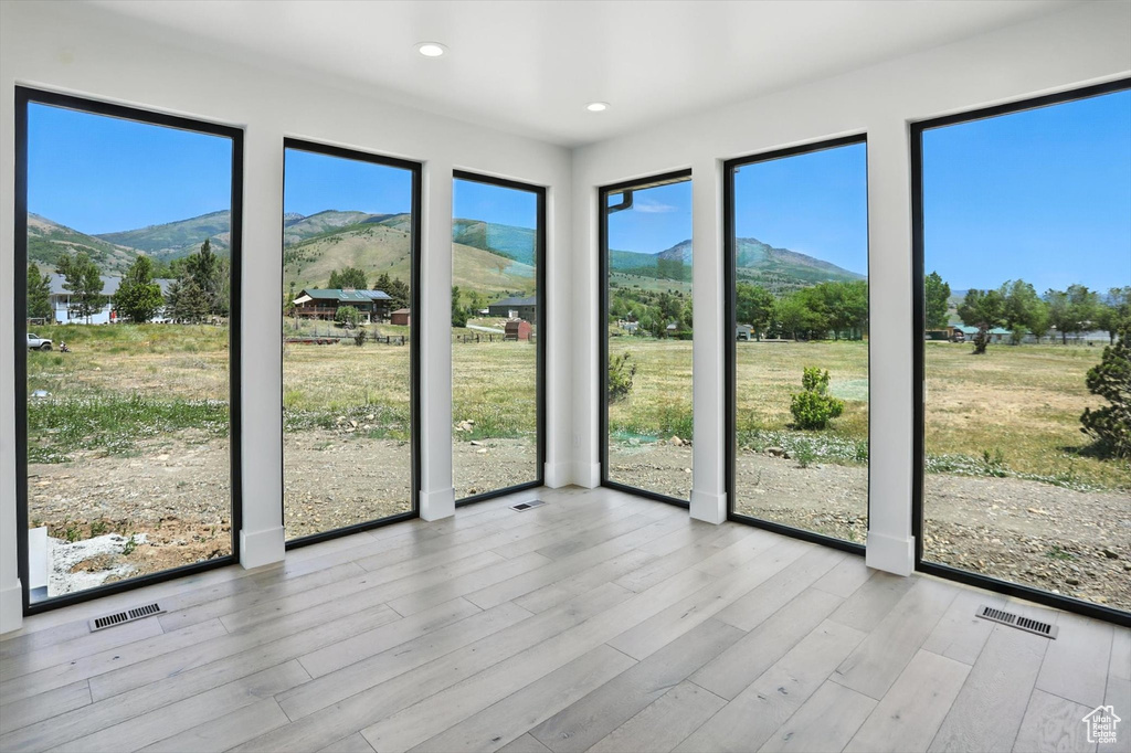 Unfurnished sunroom featuring a mountain view