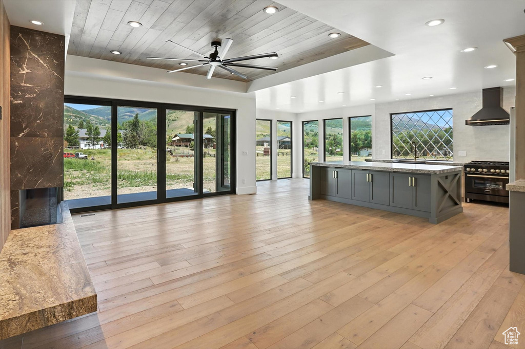 Unfurnished living room featuring wooden ceiling, recessed lighting, ceiling fan, light wood finished floors, and a high end fireplace