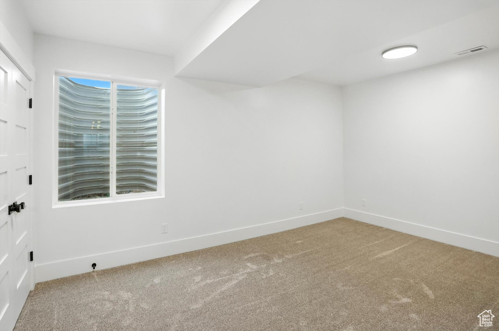 Carpeted spare room featuring baseboards