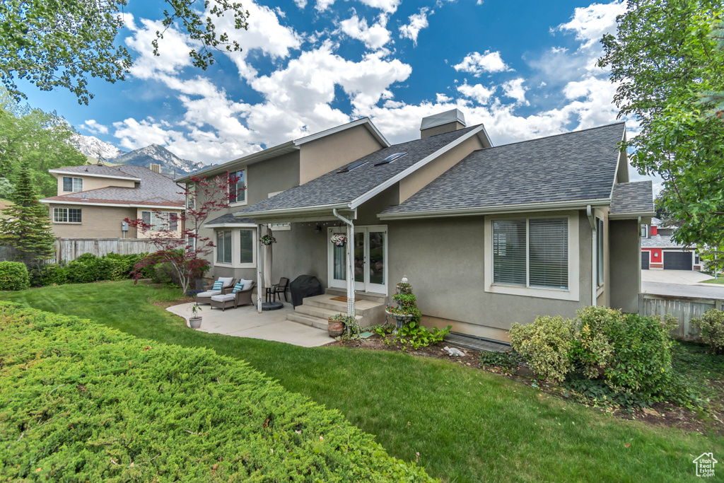 Back of property featuring stucco siding, a shingled roof, a patio area, an outdoor living space, and french doors