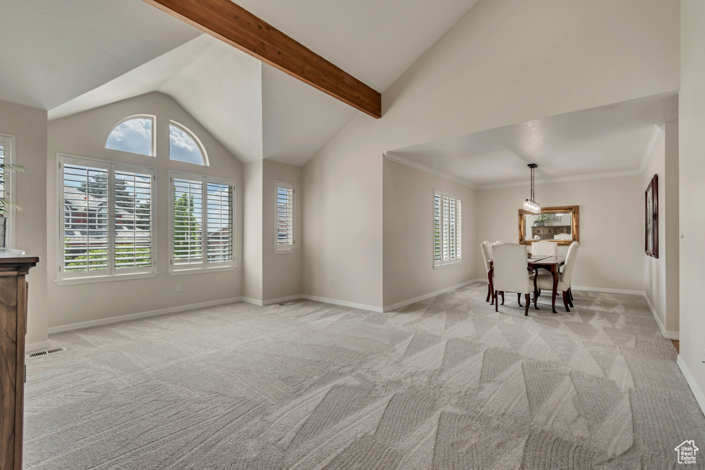 Dining area with lofted ceiling, light colored carpet, healthy amount of natural light, and baseboards