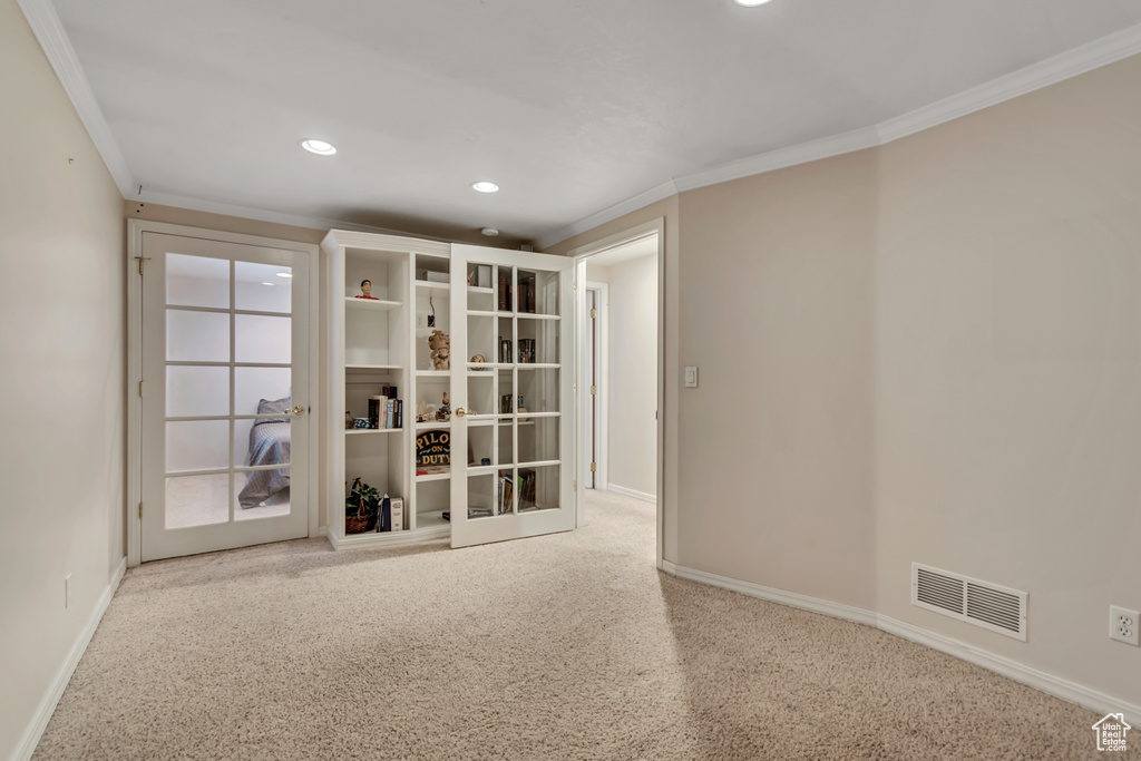 Spare room with french doors, crown molding, baseboards, recessed lighting, and carpet