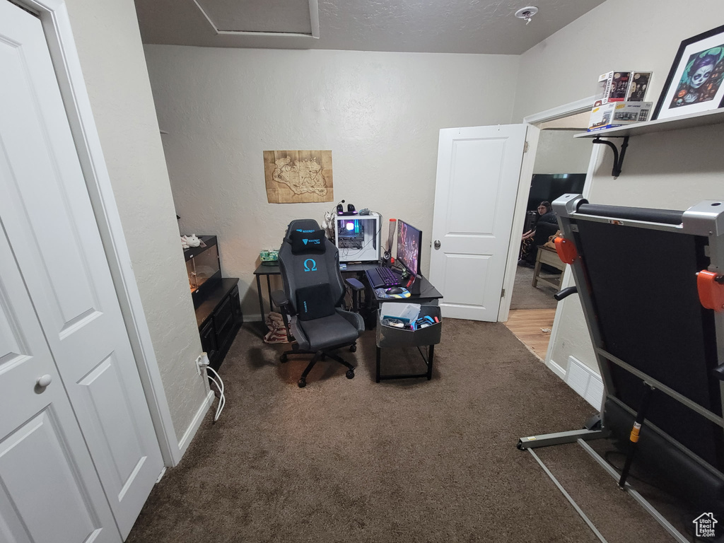 Carpeted home office featuring baseboards