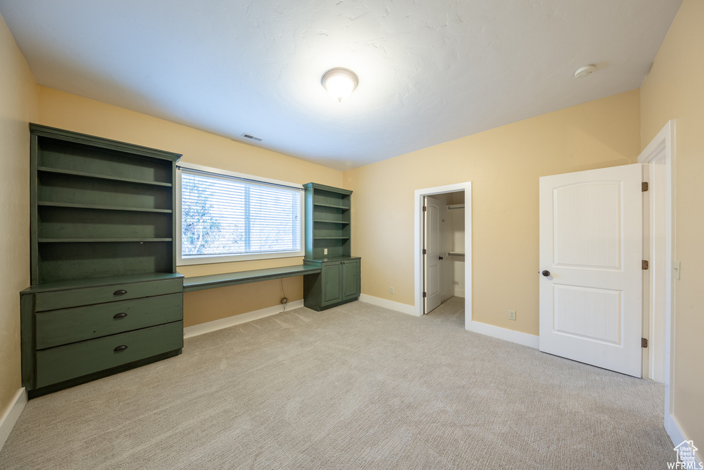Unfurnished bedroom featuring baseboards and light colored carpet
