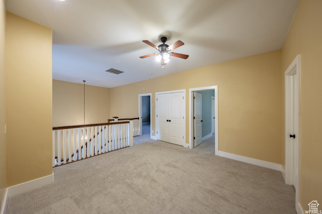 Spare room featuring ceiling fan, carpet, and baseboards