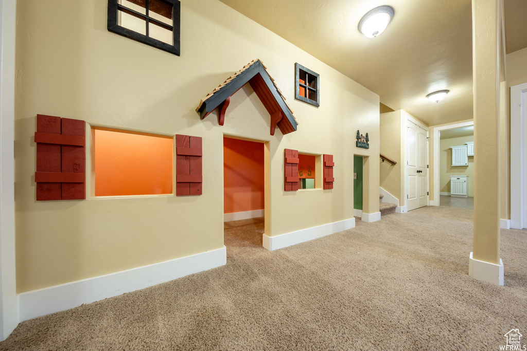 Corridor featuring carpet flooring, stairs, and baseboards