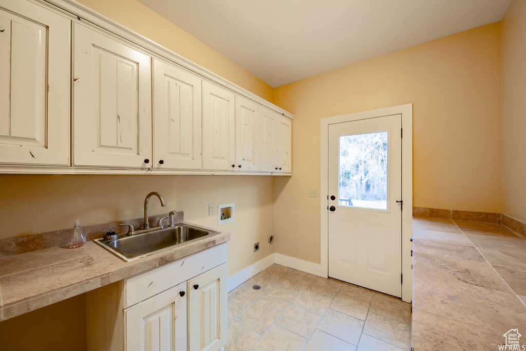 Laundry room with hookup for an electric dryer, cabinet space, washer hookup, baseboards, and light tile patterned floors