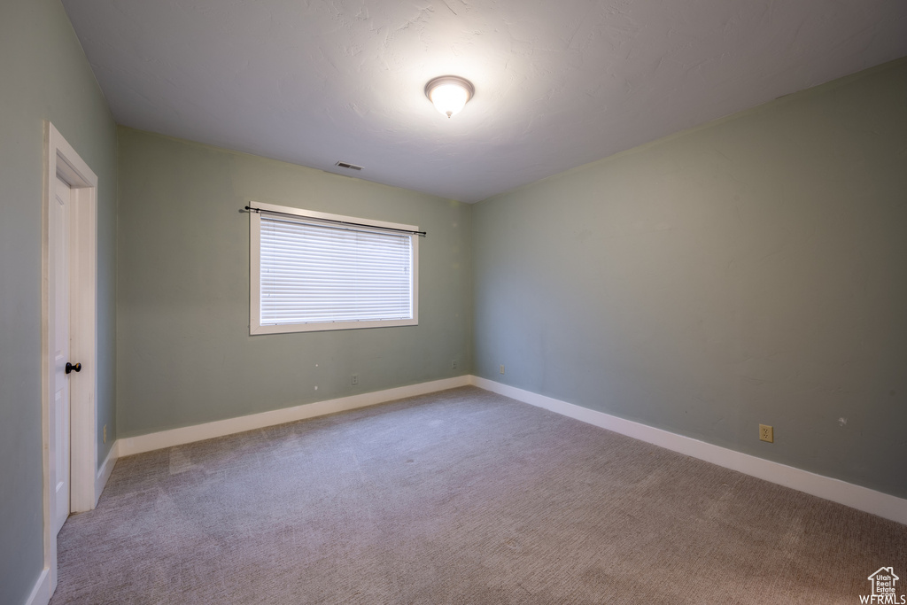 Empty room with carpet and baseboards