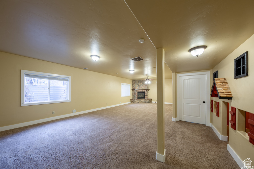 Below grade area featuring carpet flooring, baseboards, and a fireplace