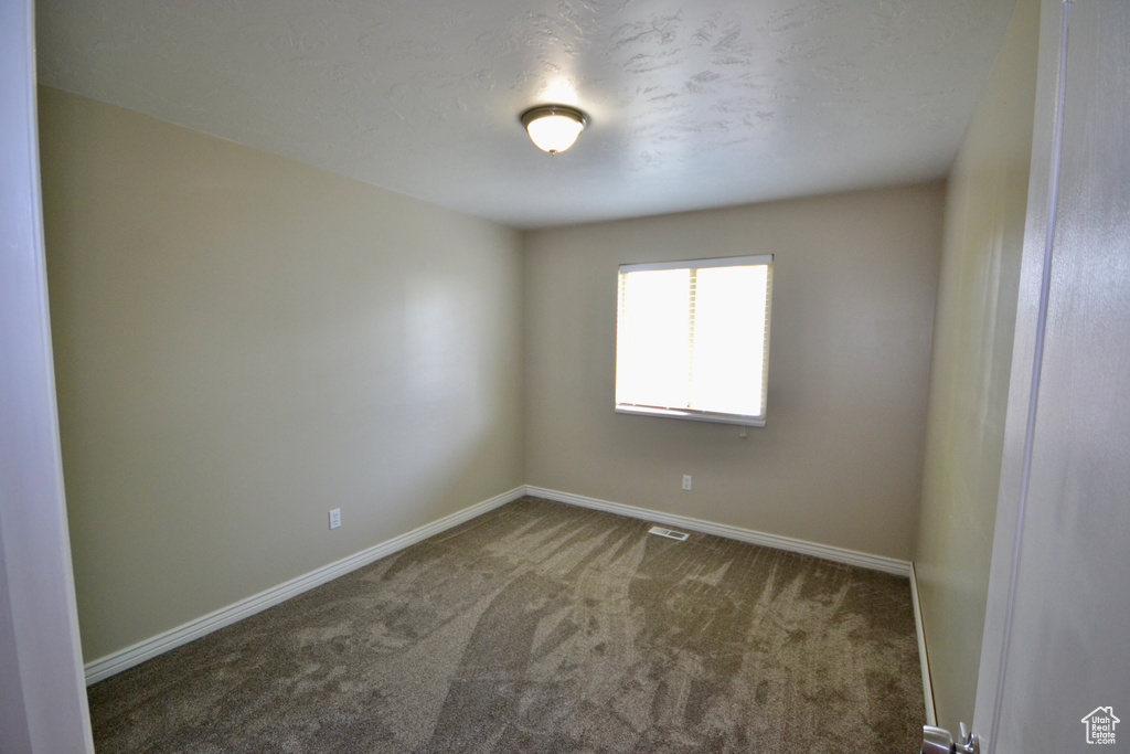 Empty room with carpet flooring and baseboards