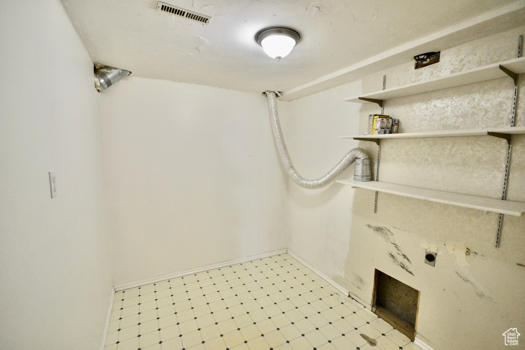 Laundry room featuring light floors, electric dryer hookup, and baseboards