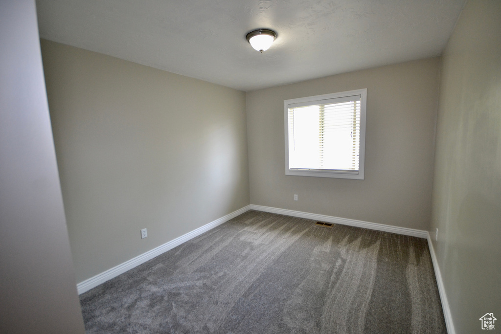 Carpeted empty room with baseboards