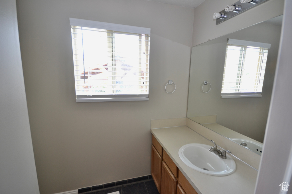 Bathroom featuring vanity, baseboards, and tile patterned floors