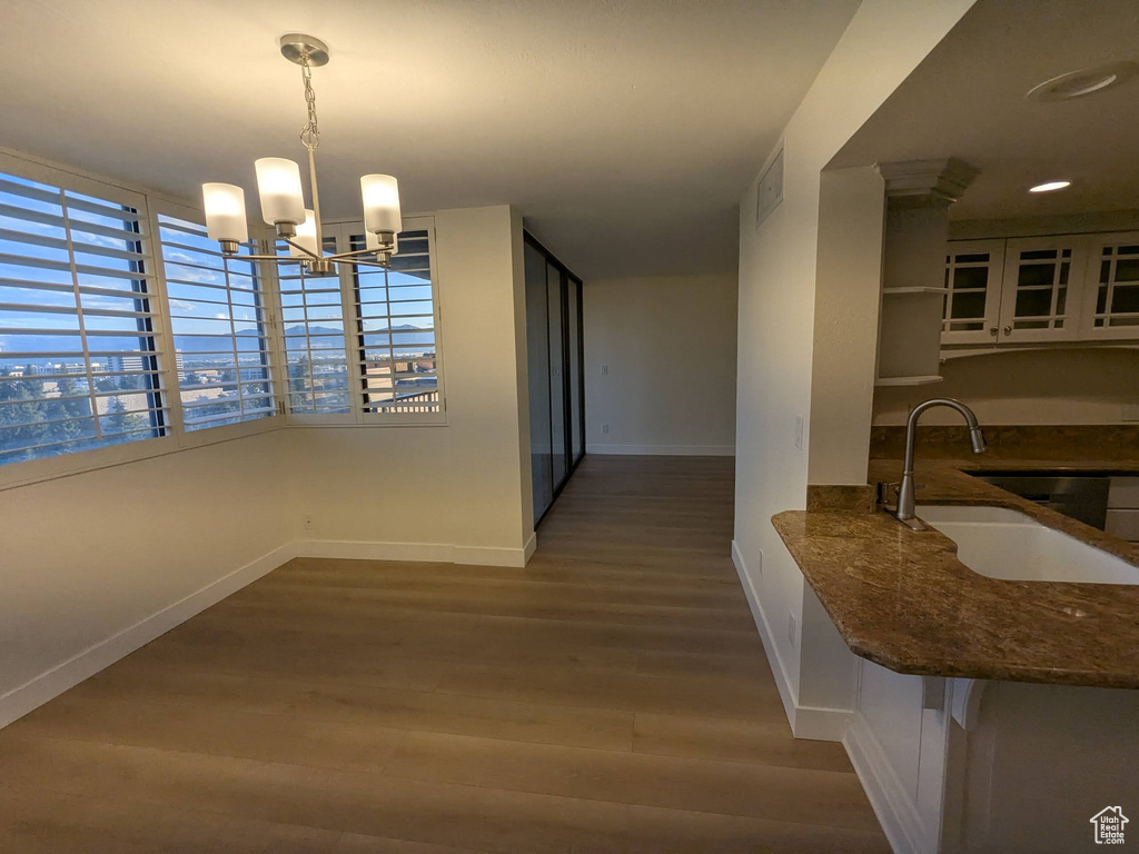 Dining room with baseboards, wood finished floors, and a chandelier