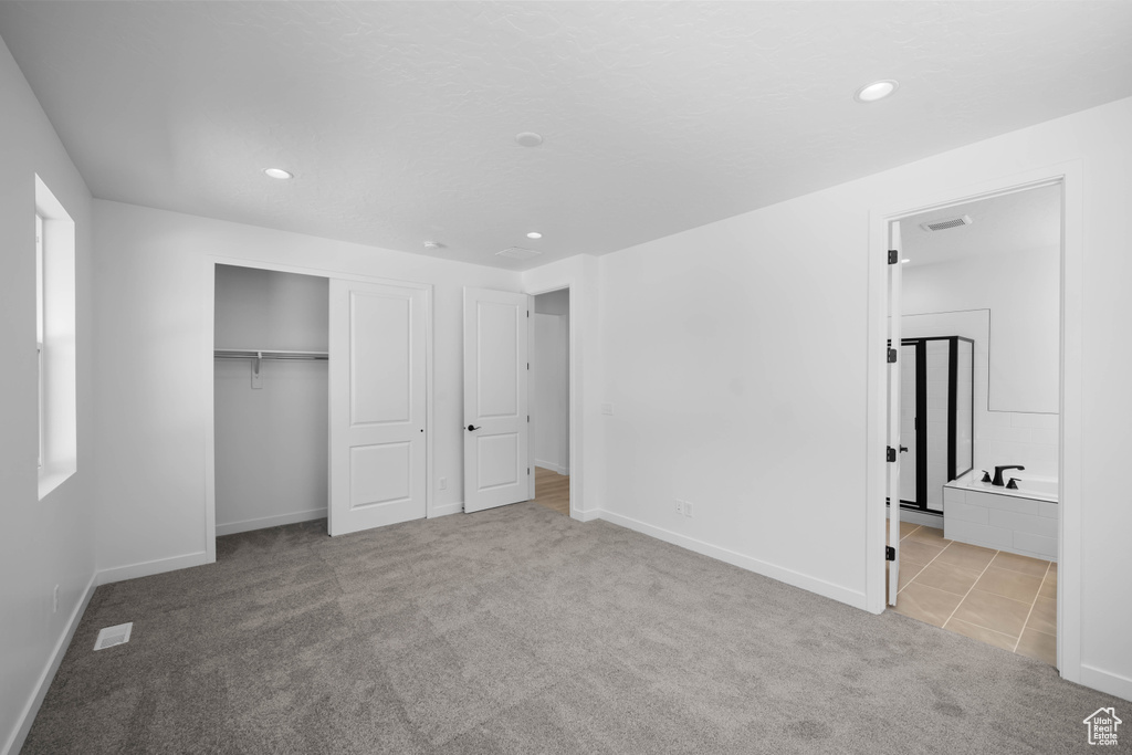Unfurnished bedroom featuring carpet, baseboards, recessed lighting, a closet, and ensuite bath