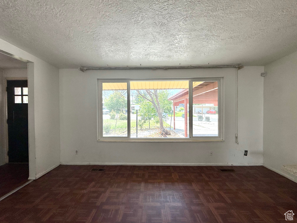 Spare room featuring a textured ceiling and baseboards