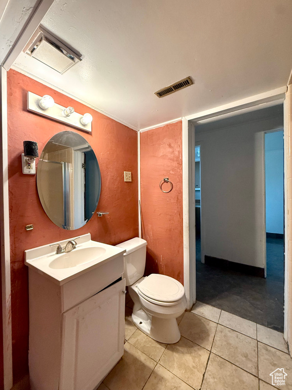 Bathroom featuring vanity, toilet, and tile patterned floors